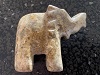 a photo of the right side of a ceramic elephent, the photo is on the left side of the page, the trunk is up & the elephent is facing the words to the right