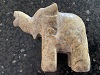 a photo of the left side of a ceramic elephent, the photo is on the right side of the page, the trunk is up & the elephent is facing the words to the left